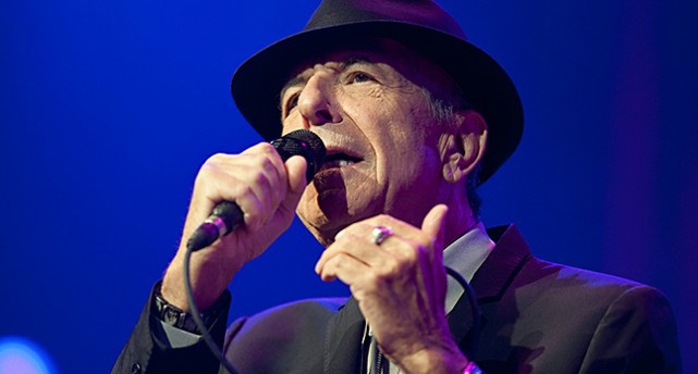 Närbild på Leonard Cohen när han sjunger.