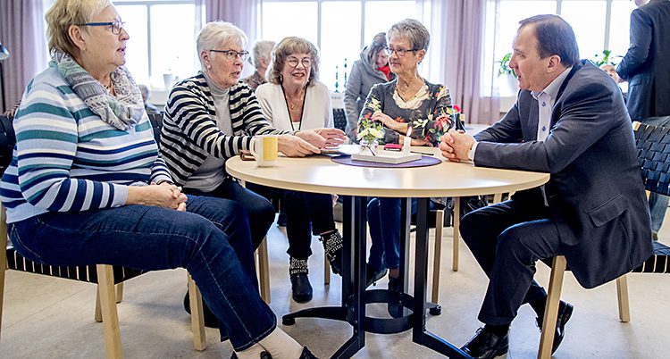 Statsminister Stefan Löfven vid ett bord med fyra äldre damer.