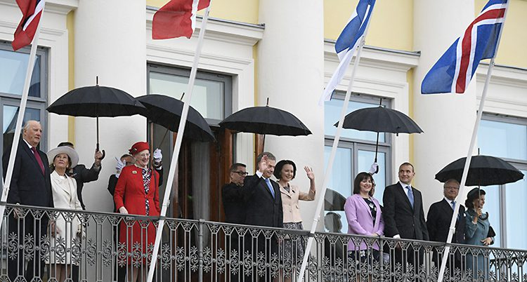 Flera kungligheter vinkar från en balkong på Finska presidentens slott.