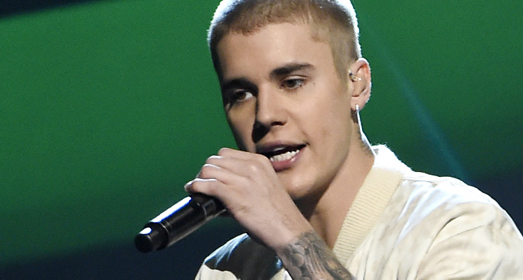Justin Bieber sjunger med en mikrofon i handen.