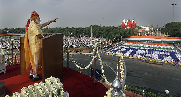 Narendra Modi står i en talarstol och talar till folket.