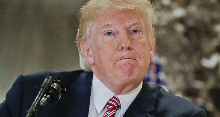 En närbild på Donald Trump. Han gör en märklig min. Han pressar ihop läpparna.