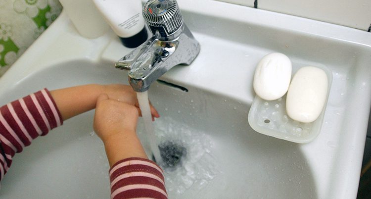 Ett barn tvättar händerna