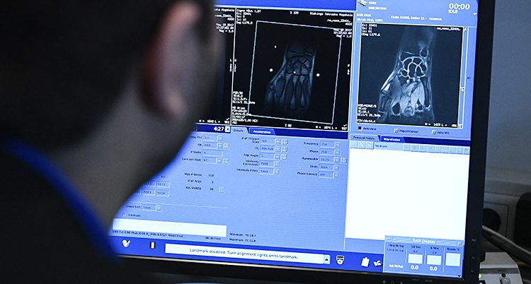 En man tittar på en datorskärm med en röntgenbild