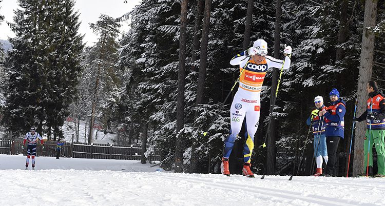 Charlotte Kalla i vita landslagsdräkten på skidor i spåret.