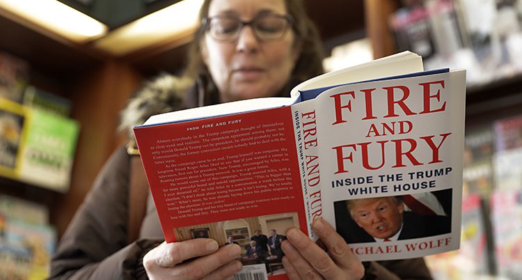 En kvinna med glasögon håller i boken som har titeln Fire and Fury.