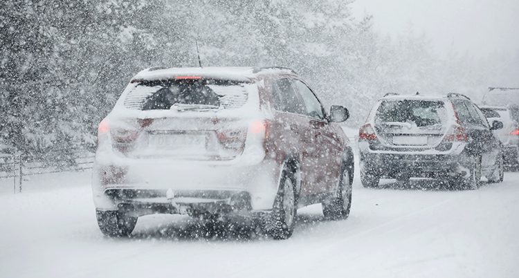 Bilar på väg genom snön.