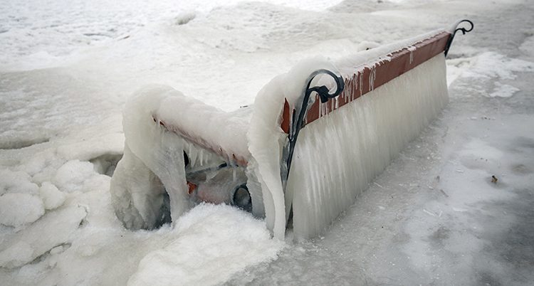 En bänk täckt av is och snö i Unger