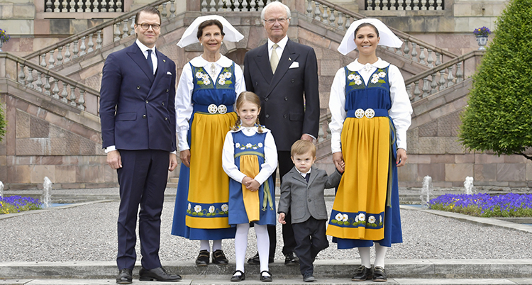 Kungen och Silvia med Daniel och Victoria och deras två barn. Kvinnorna har folkdräkter i gult och blått. Männen har kostym.