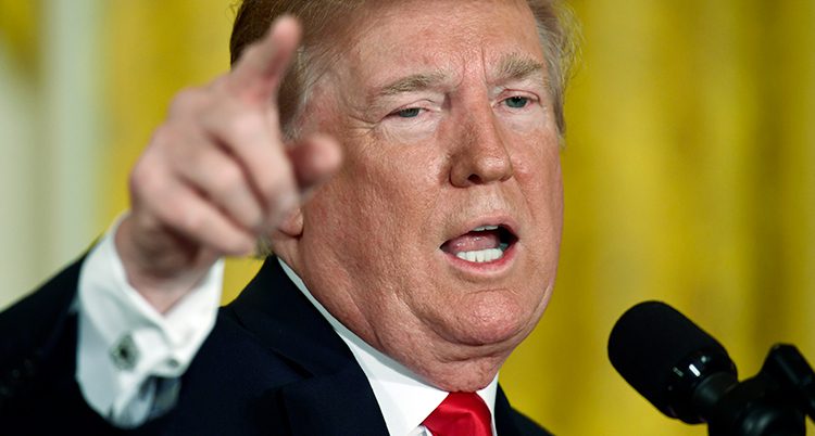 En närbild på Donald Trump som pekar med fingret framför en mikrofon.