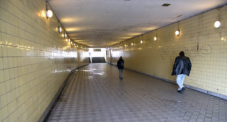 Några personer går genom en lång tunnel i Stockholm.