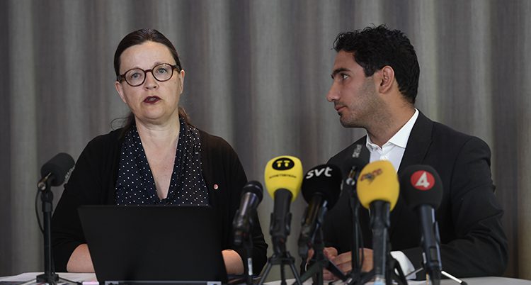 Anna Ekström och Ardalan Shekarabi står framför flera mikrofoner.