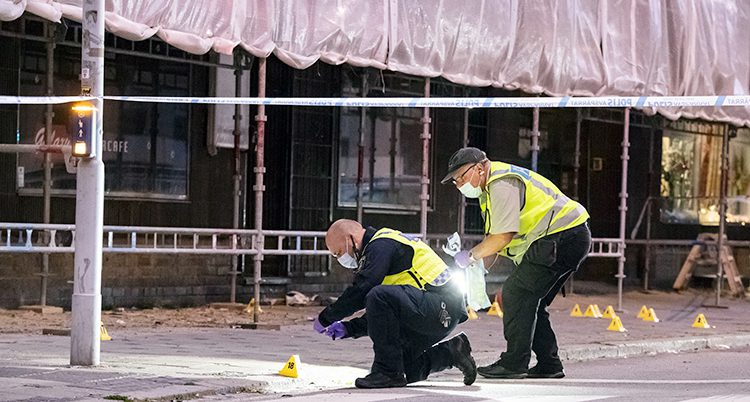 Tekniker från polisen undersöker bevis på en gata i Malmö.