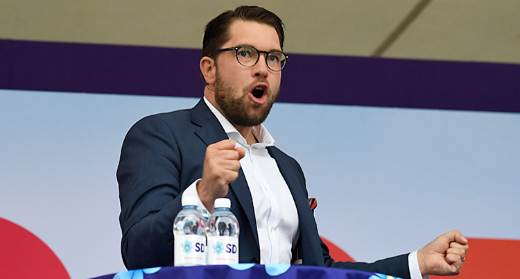 Jimmie Åkesson knyter näven när han står i talarstolen.