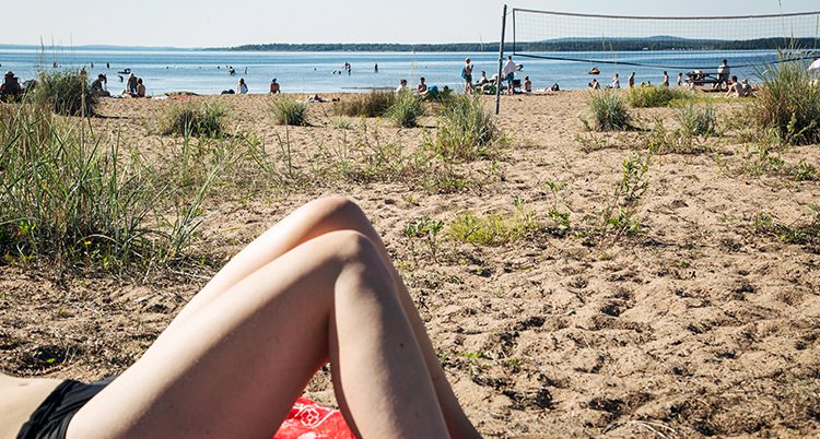 En kvinna solar på en strand.