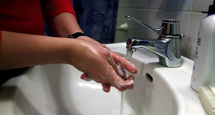En person tvättar händerna.