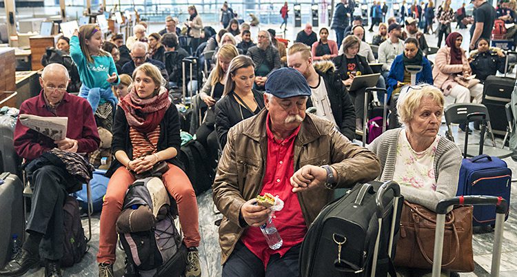 Människor sitter och väntar på flygplatsen.