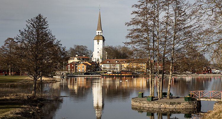 En kyrka vid en sjö. Tornet speglar sig i vattnet.