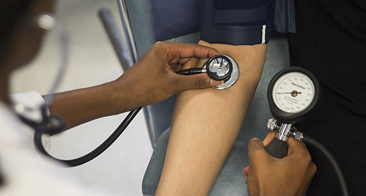 Händer med apparater för att mäta blodtryck