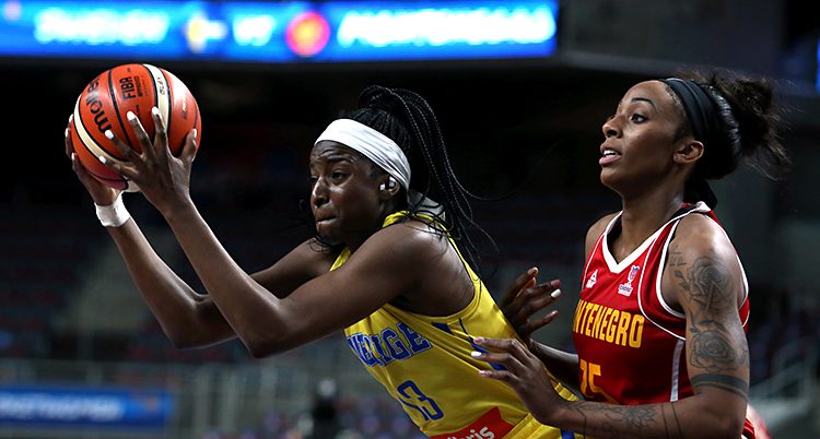 Två spelare kämpar om bollen i basket.