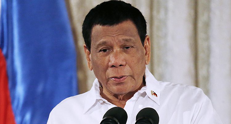 Rodrigo Duterte i vit skjorta framför en mikrofon.