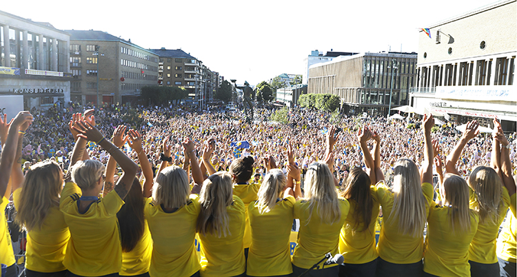 Svenskorna i gula tröjor lyfter armarna mot den enormt stora publiken på Avenyn.
