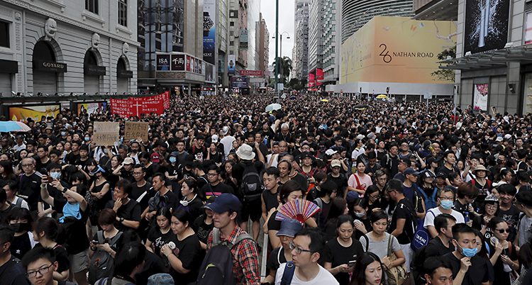 Människor trängs på en bred gata i Hongkong.