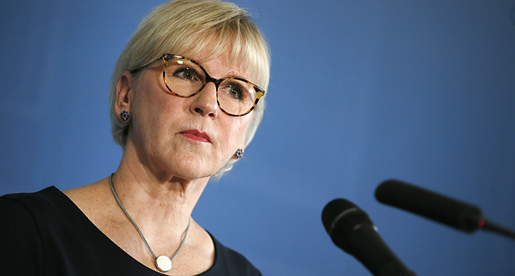 Margot Wallström står vid mikrofoner och pratar för journalister.