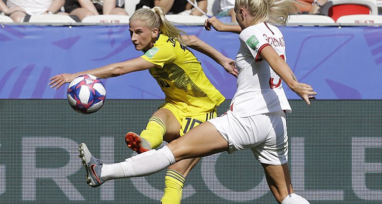 Sofia Jakobsson kämpar om bollen med en engelsk spelare i en match i fotboll.