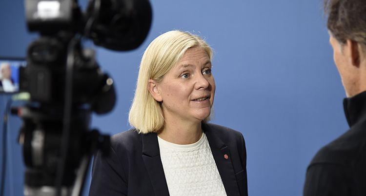 Magdalena Andersson pratar med en journalist. Hon ser både glad och bekymrad ut.