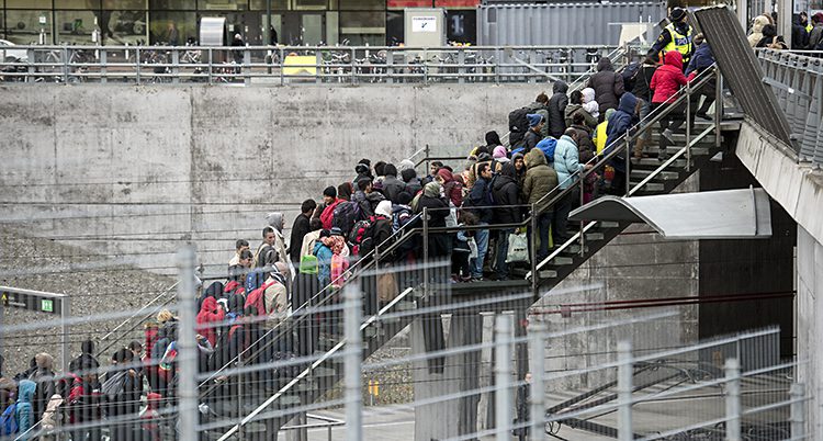 Ett foto av en trappa som går upp från ett tågspår. Trappan är full med människor. Det är sen höst så människor har mycket kläder på sig.