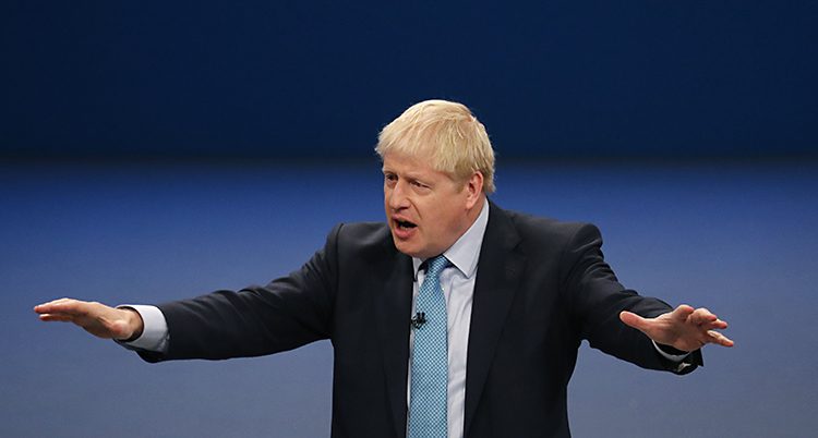 Boris J sträcker ut armarna samtidigt som han talar.