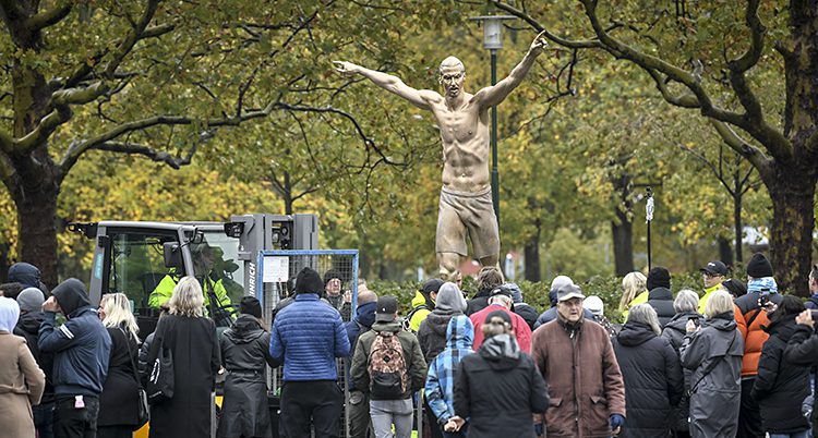 Många människor står framför en staty av fotbollspelaren Zlatan.