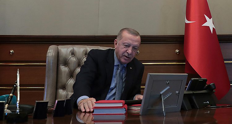 Turkiets president sitter vid ett skrivbord och pratar i telefon.