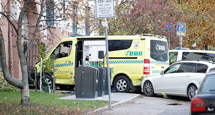 Bilden visar en gata i Oslo. En ambulans står nära ett hus. Flera andra bilar står nära den.