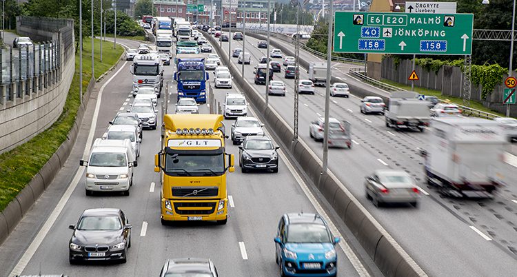 Lastbilar och bilar kör på en trafikerad väg.