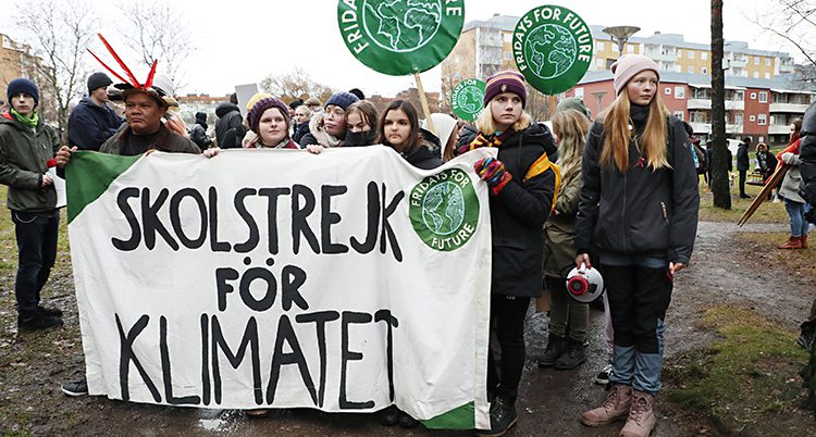 Barn håller i en banderoll med texten Skolstrejk för klimatet