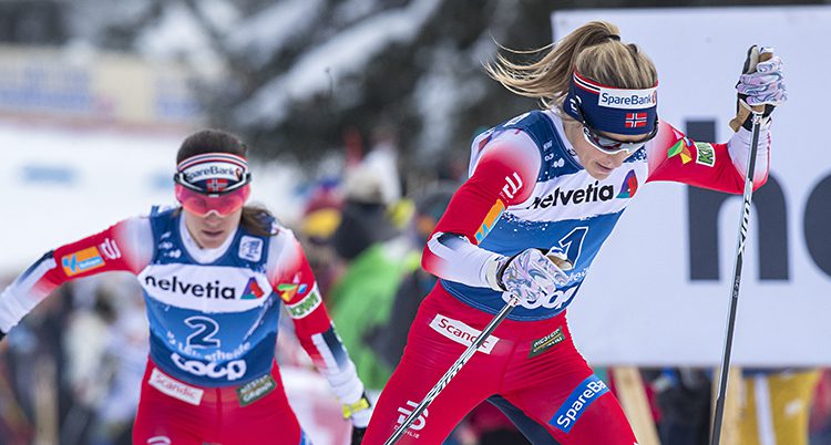 Två norska skidåkare kämpar i en backe.