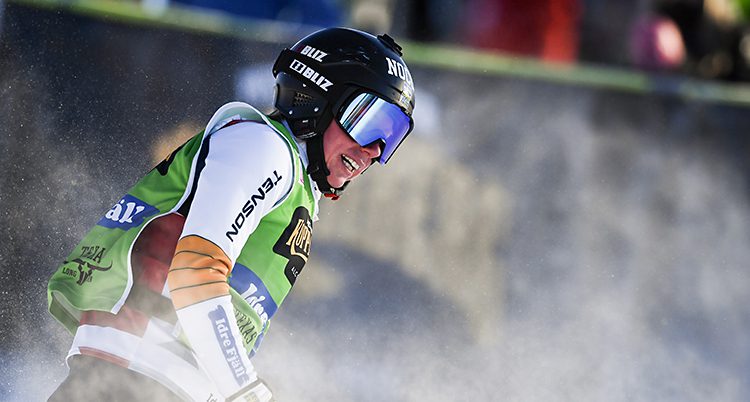 Sandra Näslund har precis gått i mål i en tävling i skicross. Hon har på sig tävlingsdräkt, hjälm och skidglasögon.
