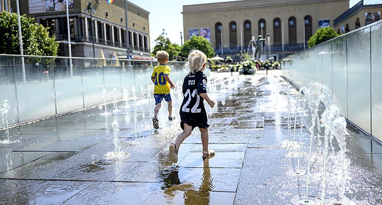 Några barn leker vid en fontän. I bakgrunden syns Götaplatsen i Göteborg.