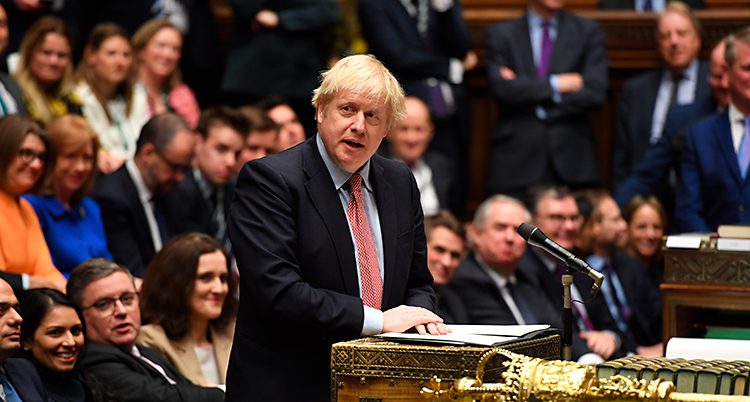 Boris Johnson står och talar i riksdagen i London. Runt om honom sitter en massa politiker.