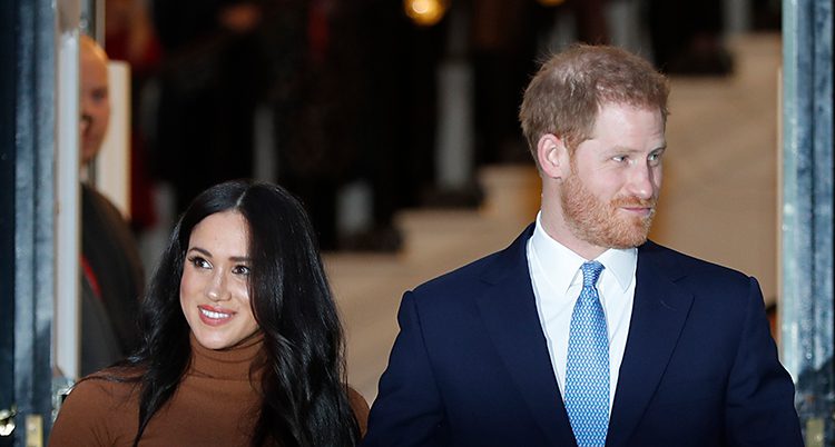 Meghan har svart hår och ler. Prinsen har rött hår, kavaj och slips