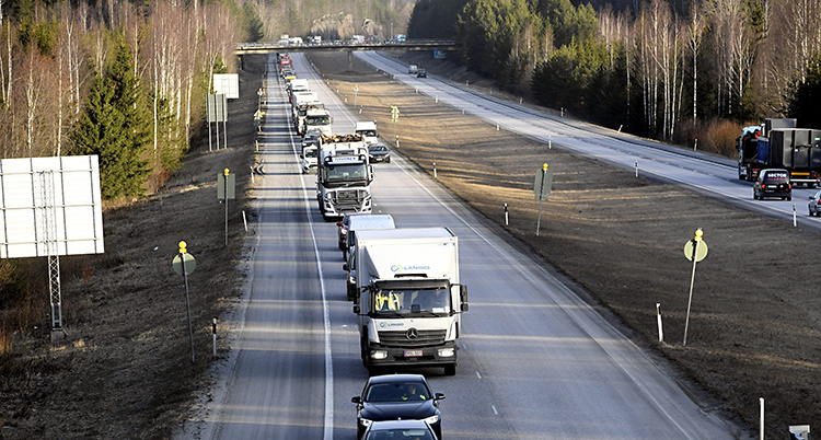 En motorväg med många bilar och lastbilar efter varandra.