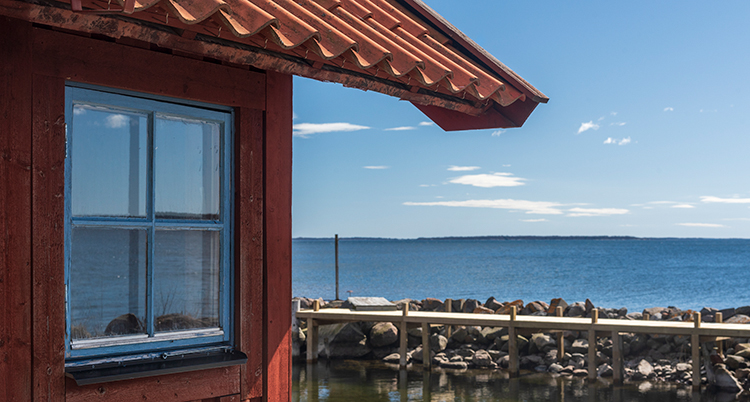 Ett rött hus med utsikt över vattnet.