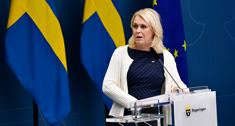 Socialminister Lena Hallengren pratar i en mikrofon.