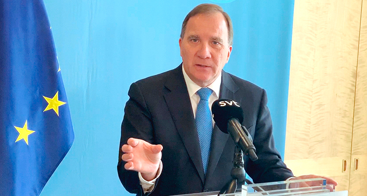 Stefan Löfven pratar på en presskonferens. I bakgrunden syns EUs flagga.