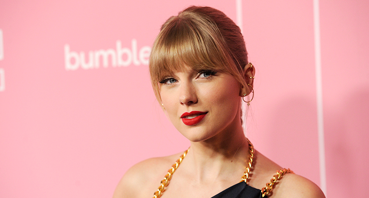 Taylor Swift har rött läppstift och uppsatt hår. Ett foto från en gala.