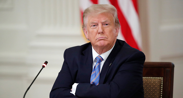 Donald Trump sitter med armarna i kors och ser arg ut.