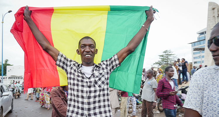 En man håller i Malis flagga när han firar på huvudstaden Bamakos gator.
