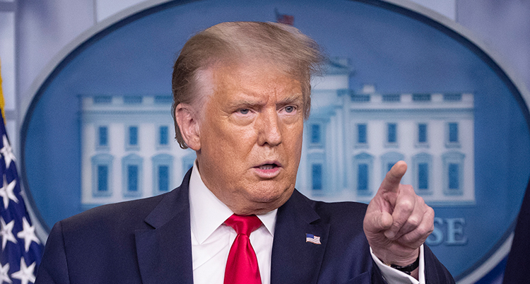 Trump ser arg ut och pekar med ett finger på någon.